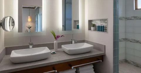 Double vanity and walk-in shower in a suite bathroom at Sandals Regency La Toc.
