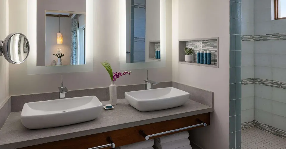 Double vanity and walk-in shower in a suite bathroom at Sandals Regency La Toc.