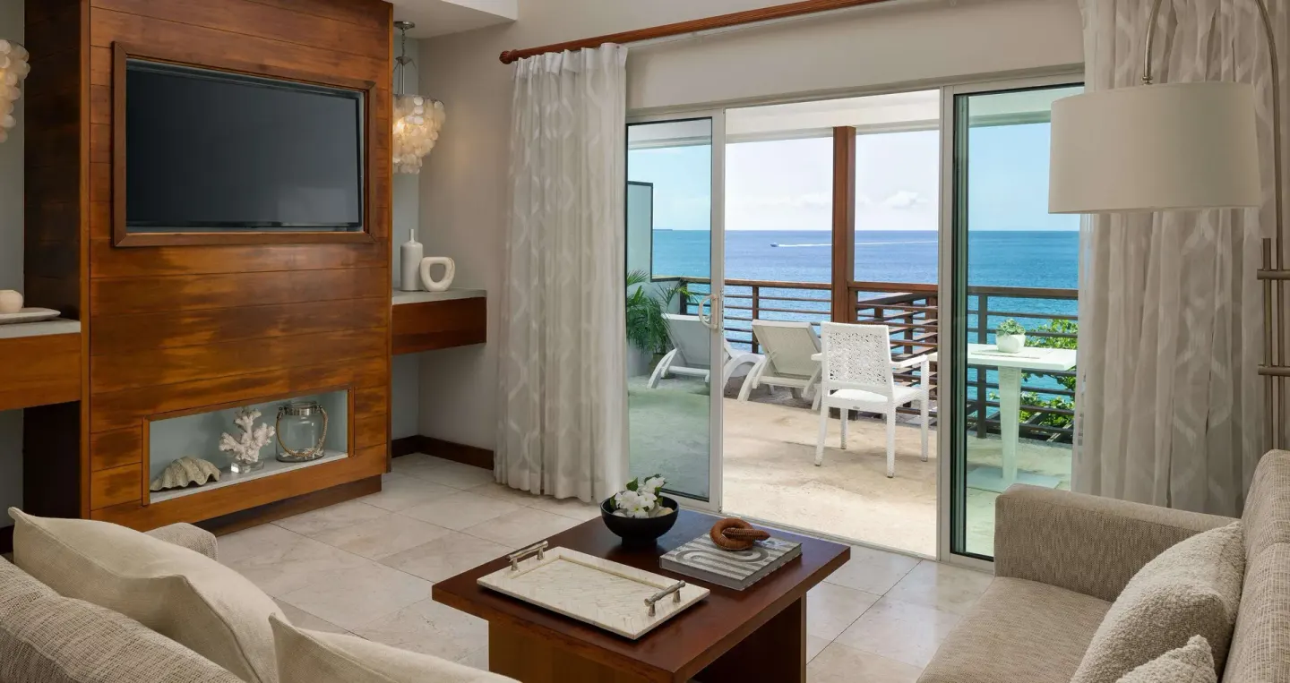 Ocean-view villa suite living room with balcony at Sandals Regency La Toc.