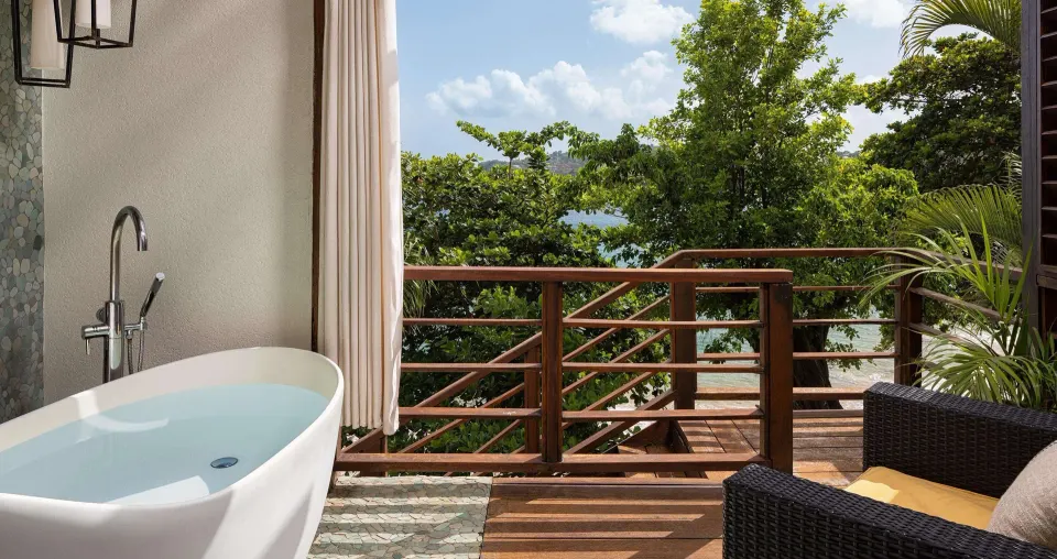 Outdoor soaking tub and balcony seating at Sandals Regency La Toc.
