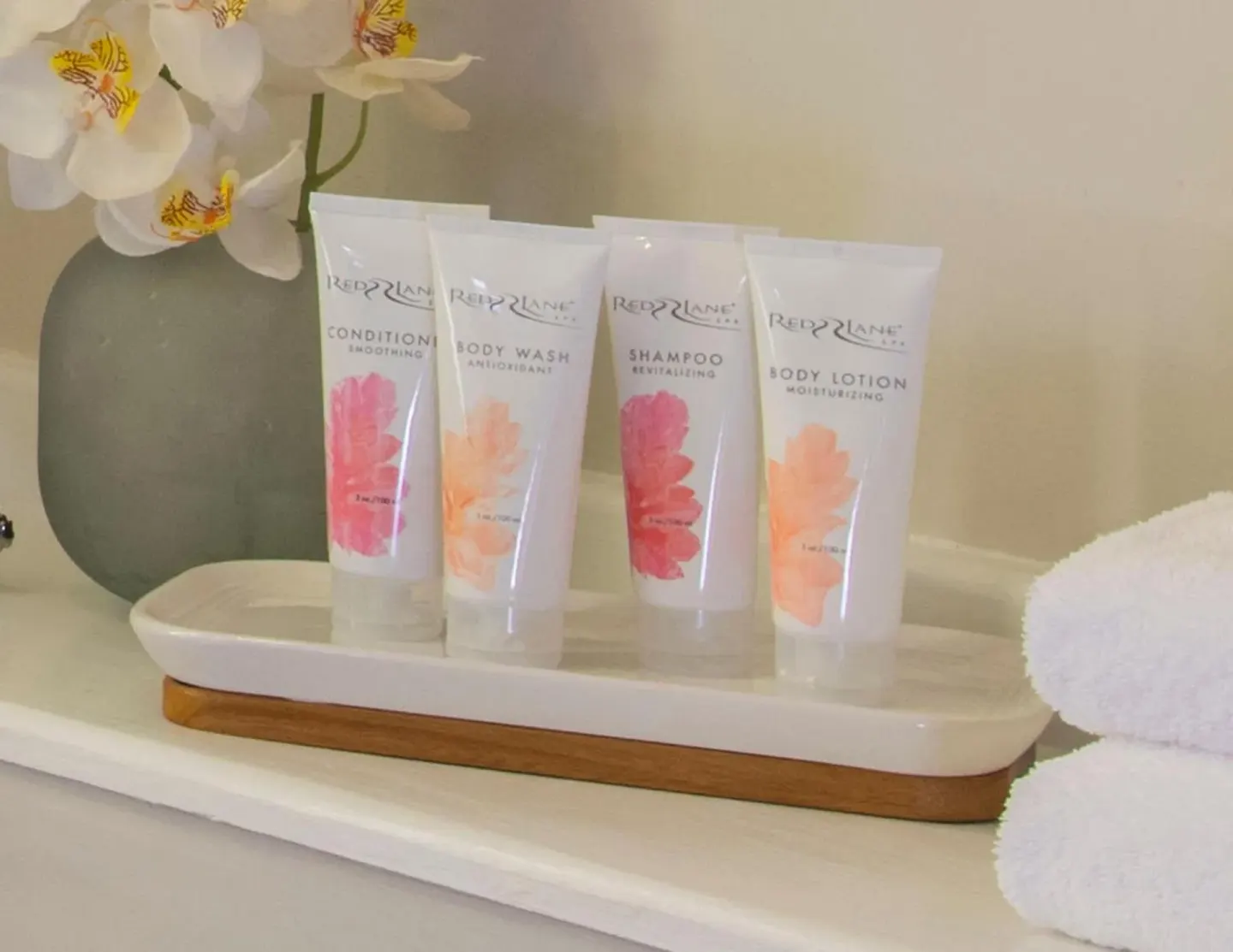 Bathroom amenities, towels and flowers in a guest room at Sandals Regency La Toc.