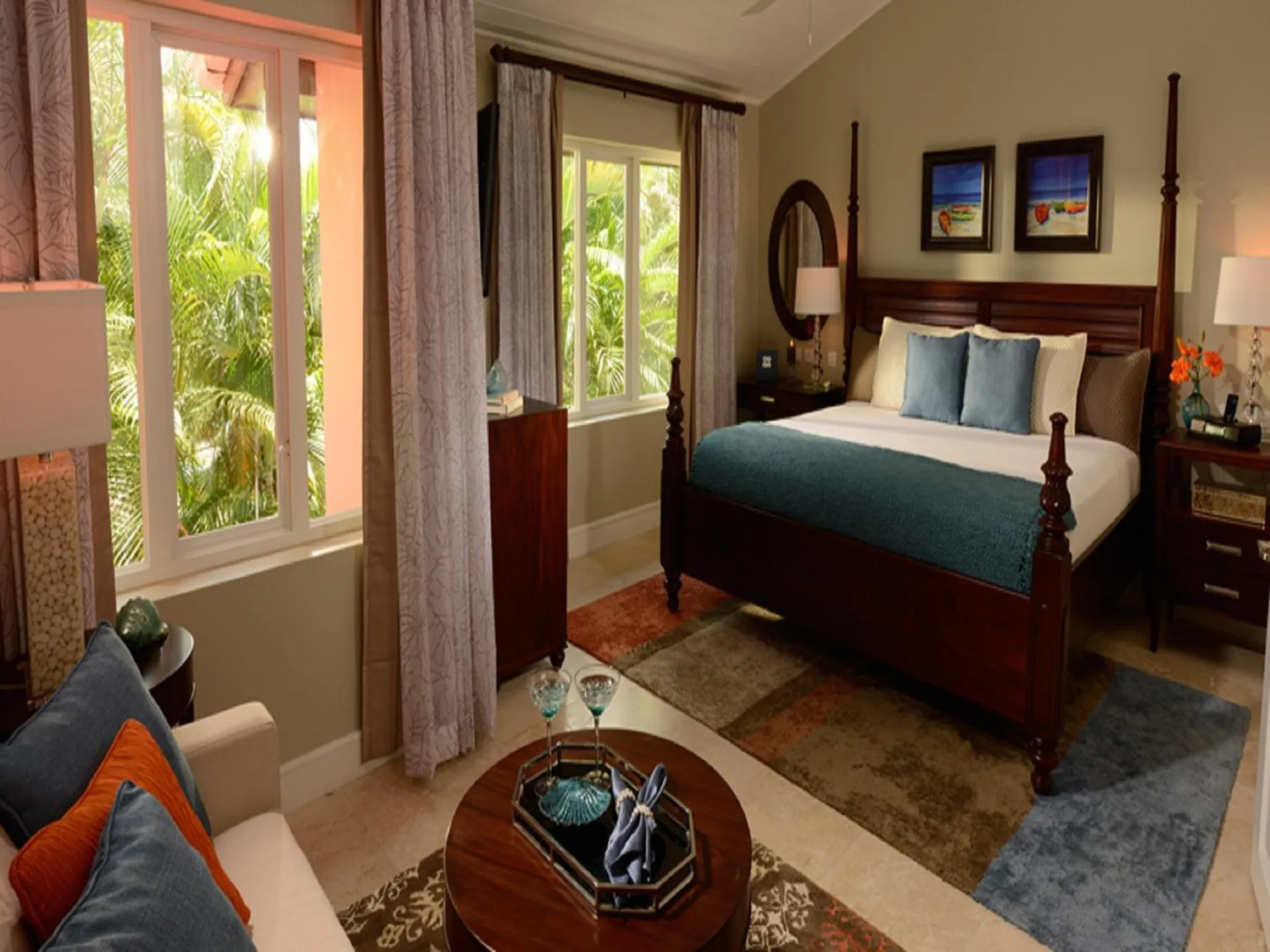 Four-poster king bed and seating area in a guest room at Sandals Regency La Toc.
