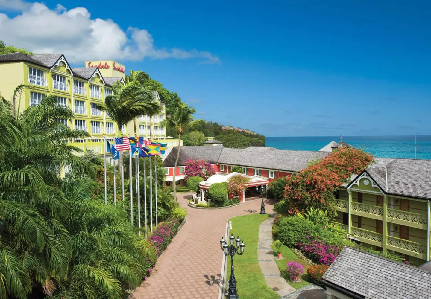 Landscaped resort buildings and ocean beyond at Sandals Regency La Toc.