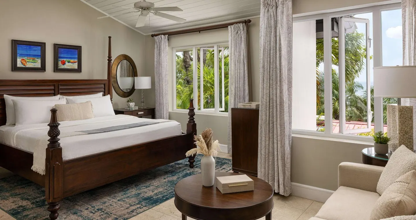 Honeymoon room with king bed, seating area, and garden-facing windows at Sandals Regency La Toc.