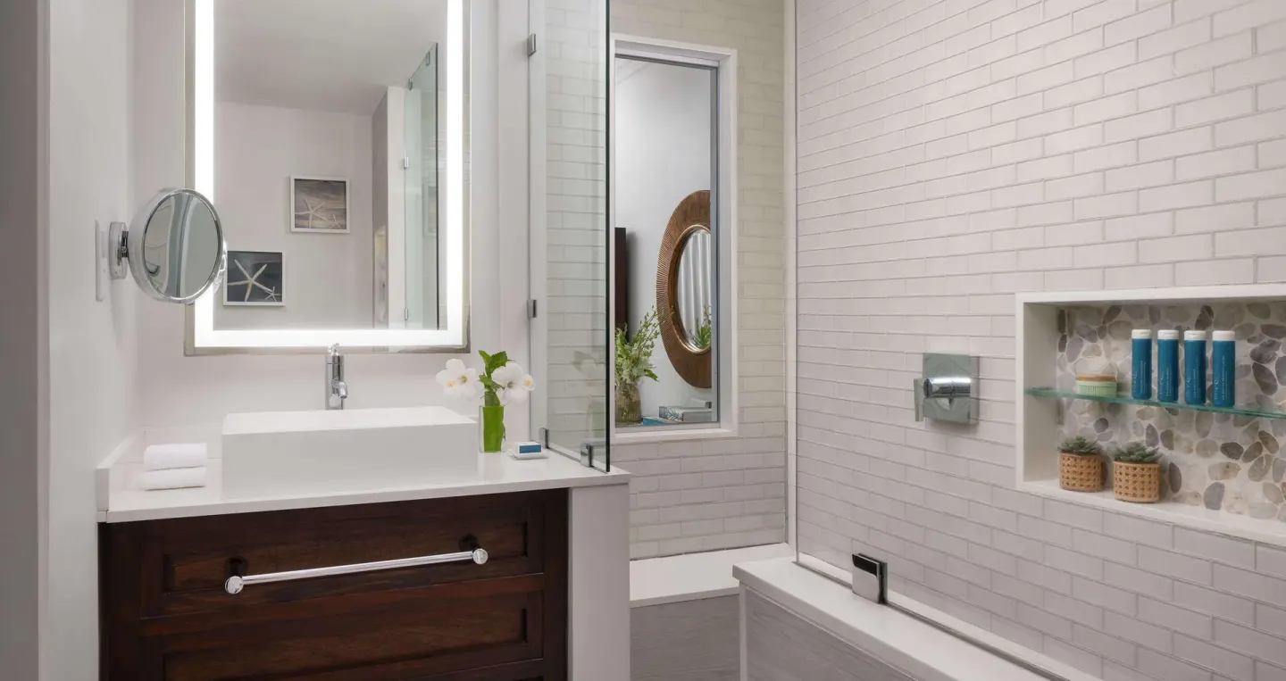 Guest bathroom with vanity and glass shower at Sandals Regency La Toc.
