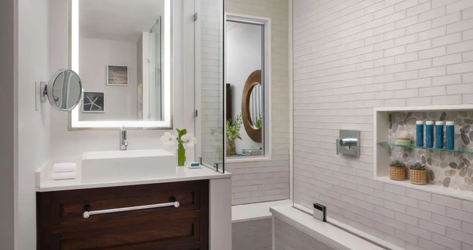 Guest bathroom with vanity and glass shower at Sandals Regency La Toc.