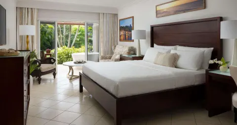 Honeymoon sanctuary junior suite king bed and garden patio at Sandals Regency La Toc.