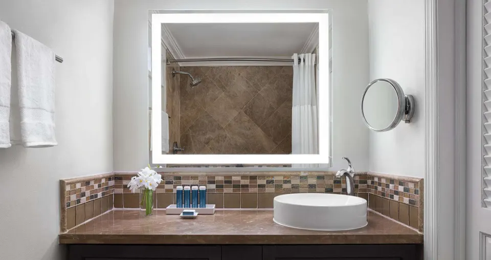 Villa bathroom vanity with vessel sink and illuminated mirror at Sandals Regency La Toc.