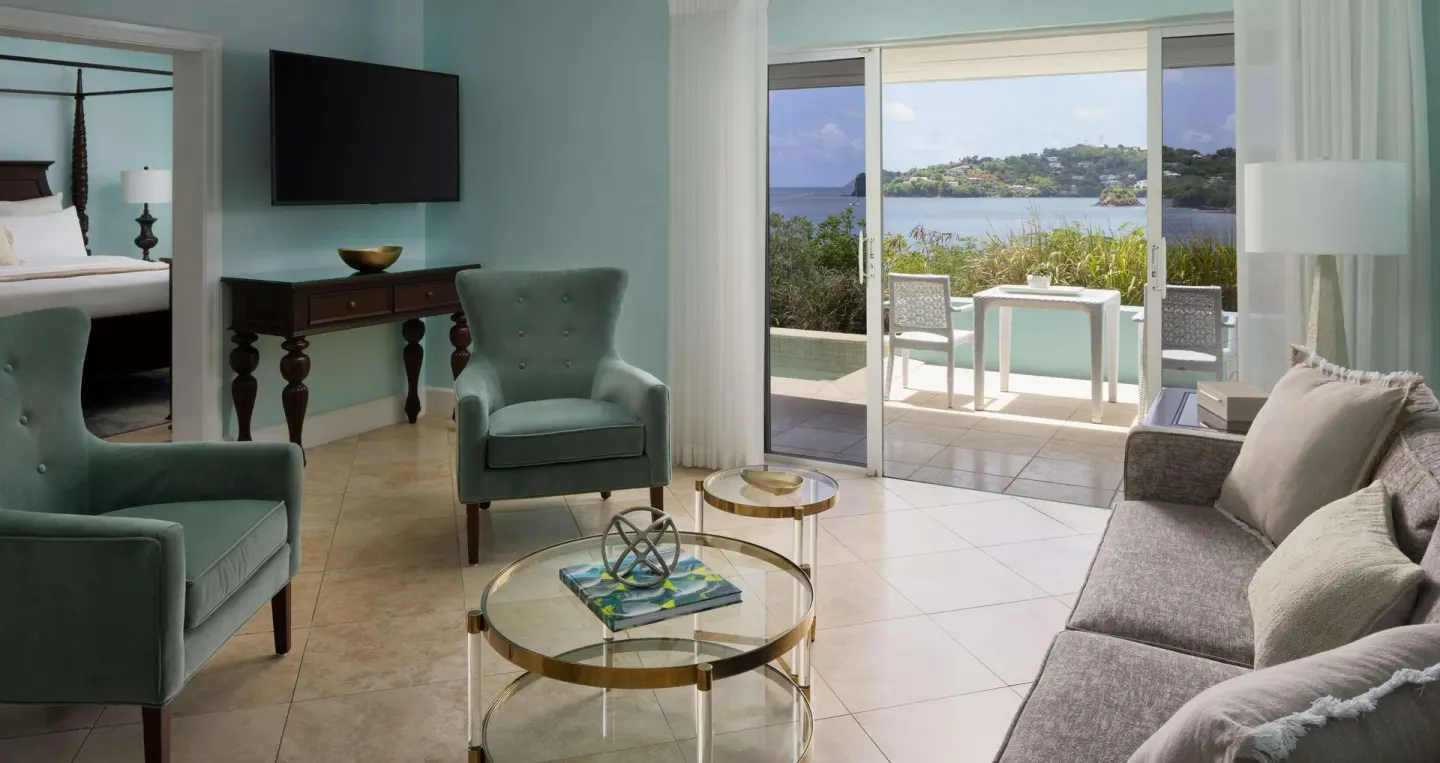 Ocean-view villa living room with terrace seating at Sandals Regency La Toc.