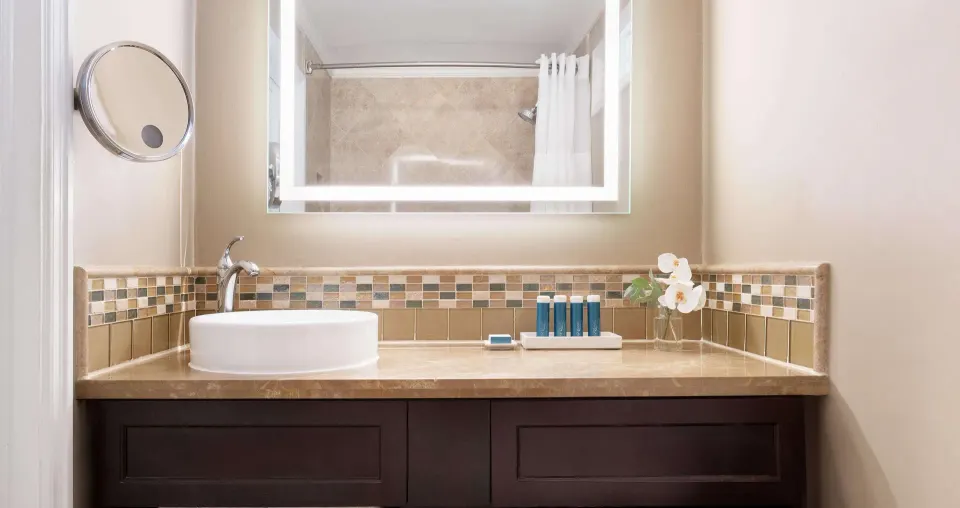 Bathroom vanity with vessel sink and mirror at Sandals Regency La Toc.