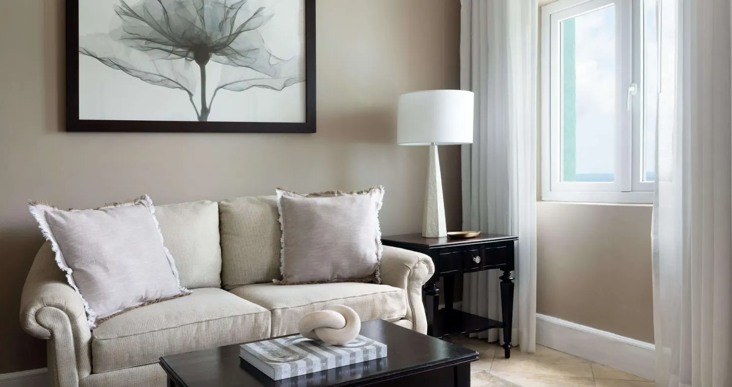 Sitting area with sofa and window in a guest room at Sandals Regency La Toc.