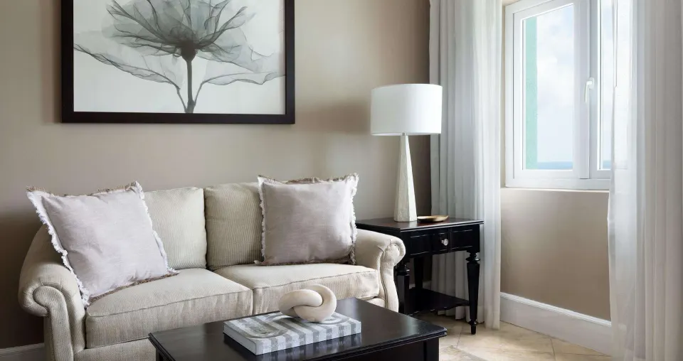 Sitting area with sofa and window in a guest room at Sandals Regency La Toc.