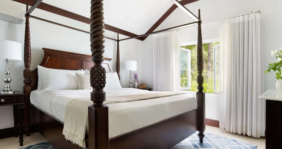 Four-poster king bed in a luxury suite bedroom at Sandals Regency La Toc.