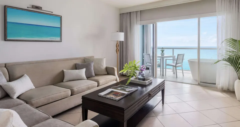 Ocean-view living room and balcony in a luxury suite at Sandals Regency La Toc.