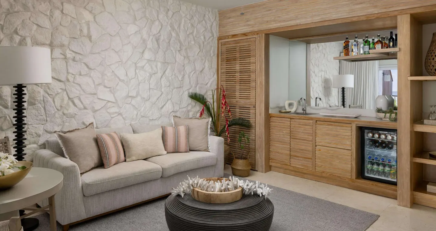 Living area with sofa and wet bar in an oceanfront villa at Sandals Regency La Toc.