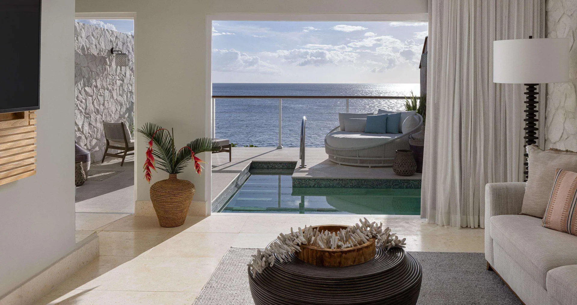Villa living room opening to a private pool and ocean view at Sandals Regency La Toc.