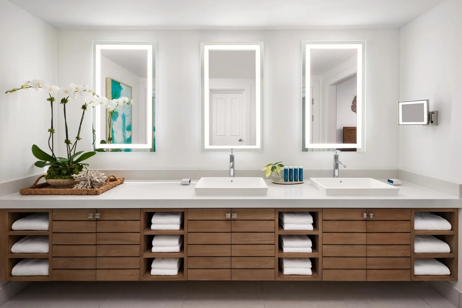 Double vanity bathroom with illuminated mirrors at Sandals Royal Bahamian.