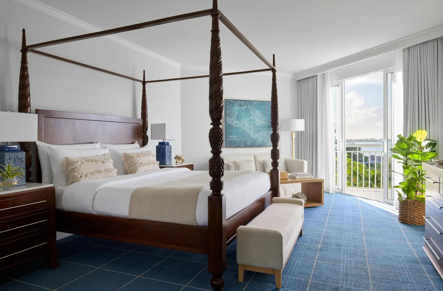 Four-poster king bedroom with balcony and water view at Sandals Royal Bahamian.