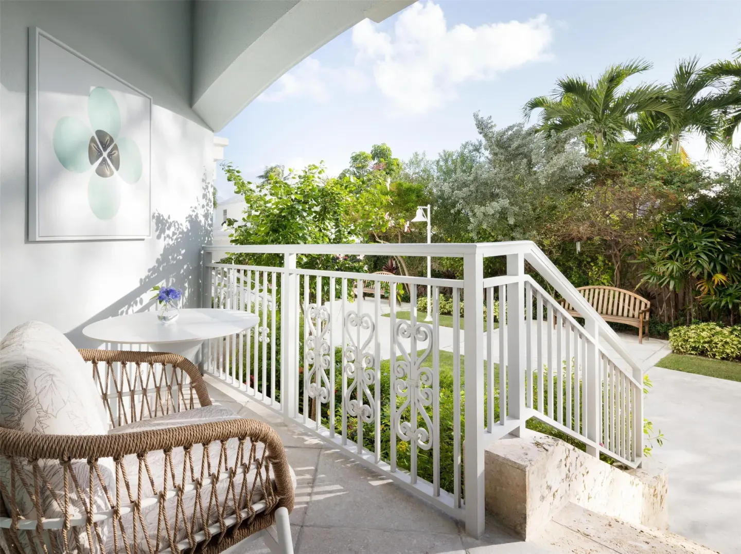 Covered patio with wicker seating and garden walkway at Sandals Royal Bahamian.