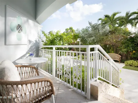 Covered patio with wicker seating and garden walkway at Sandals Royal Bahamian.