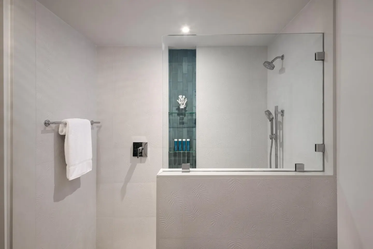 Glass shower with towel rail and bath amenities at Sandals Royal Bahamian.