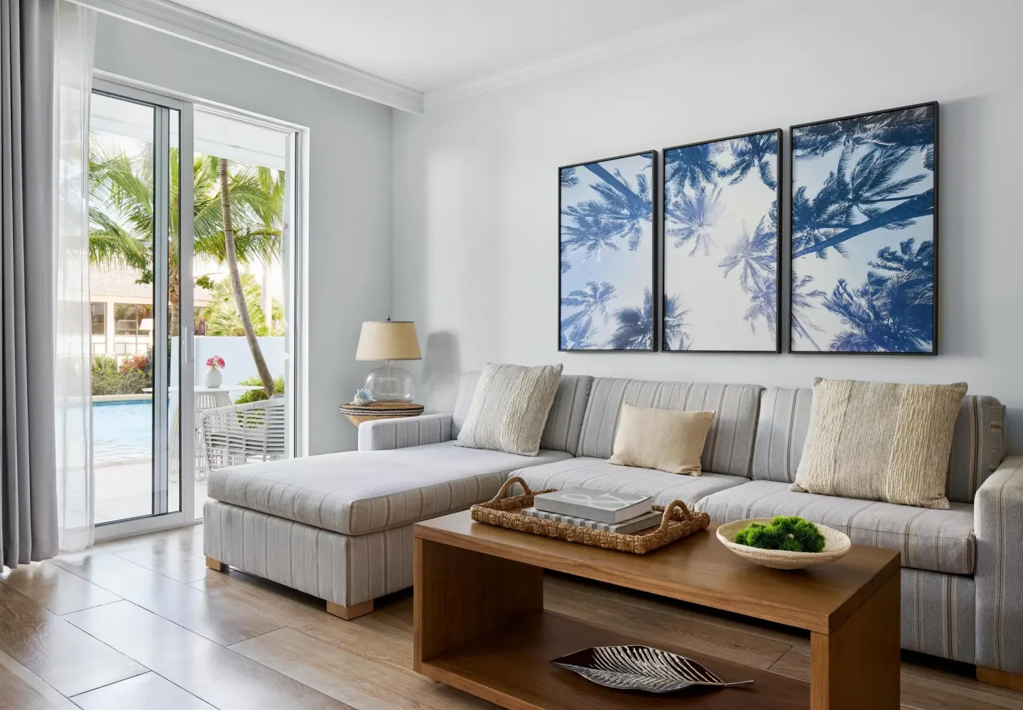 Guest suite sitting area with sectional sofa and patio view at Sandals Royal Bahamian.