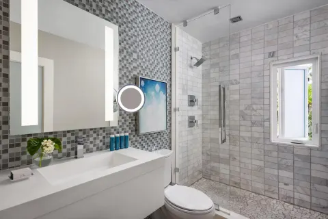 Modern bathroom with glass shower and mosaic tile at Sandals Royal Bahamian.