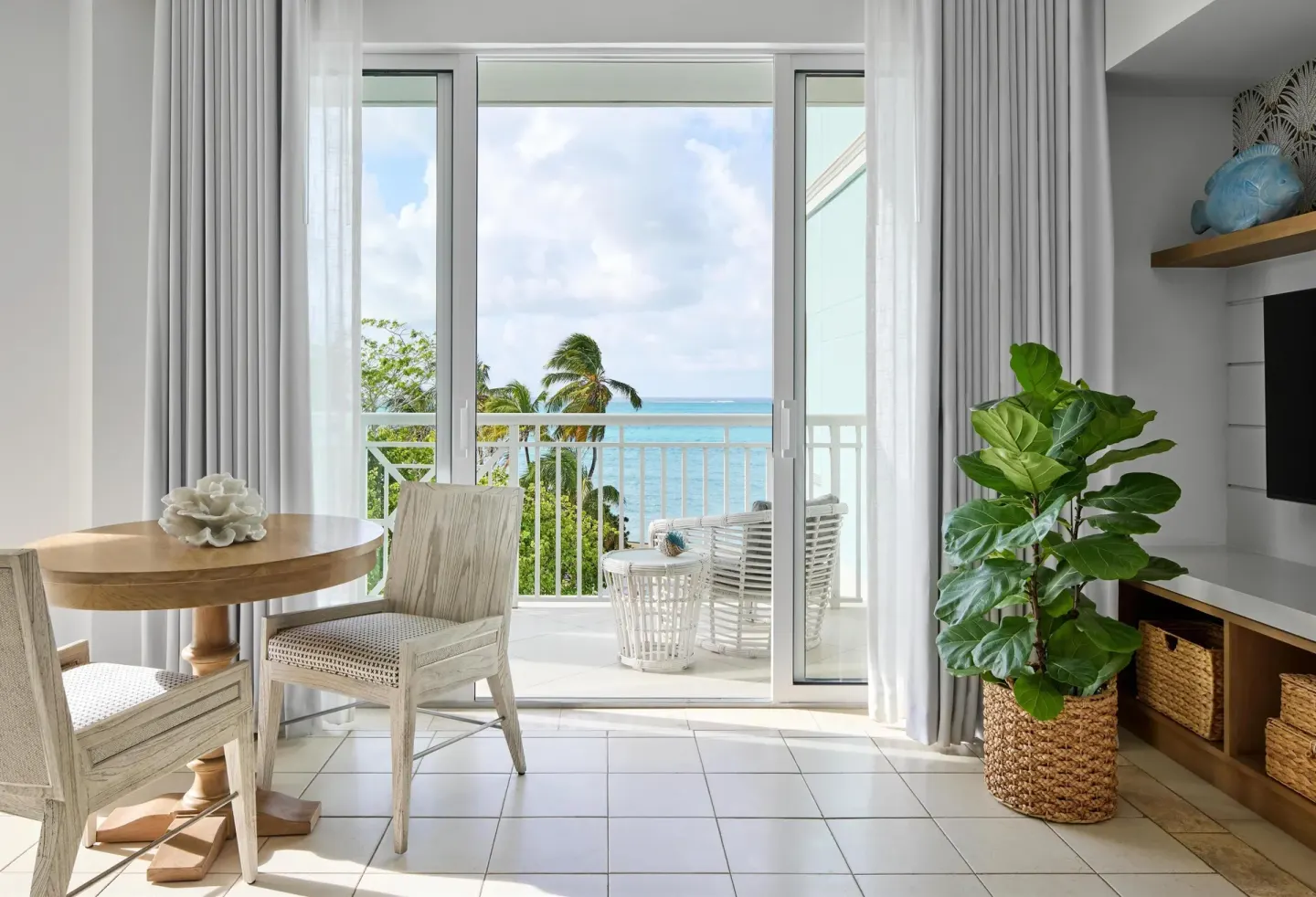 Guest sitting area with balcony and ocean view at Sandals Royal Bahamian.