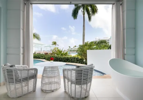 Private patio with soaking tub and pool view at Sandals Royal Bahamian.
