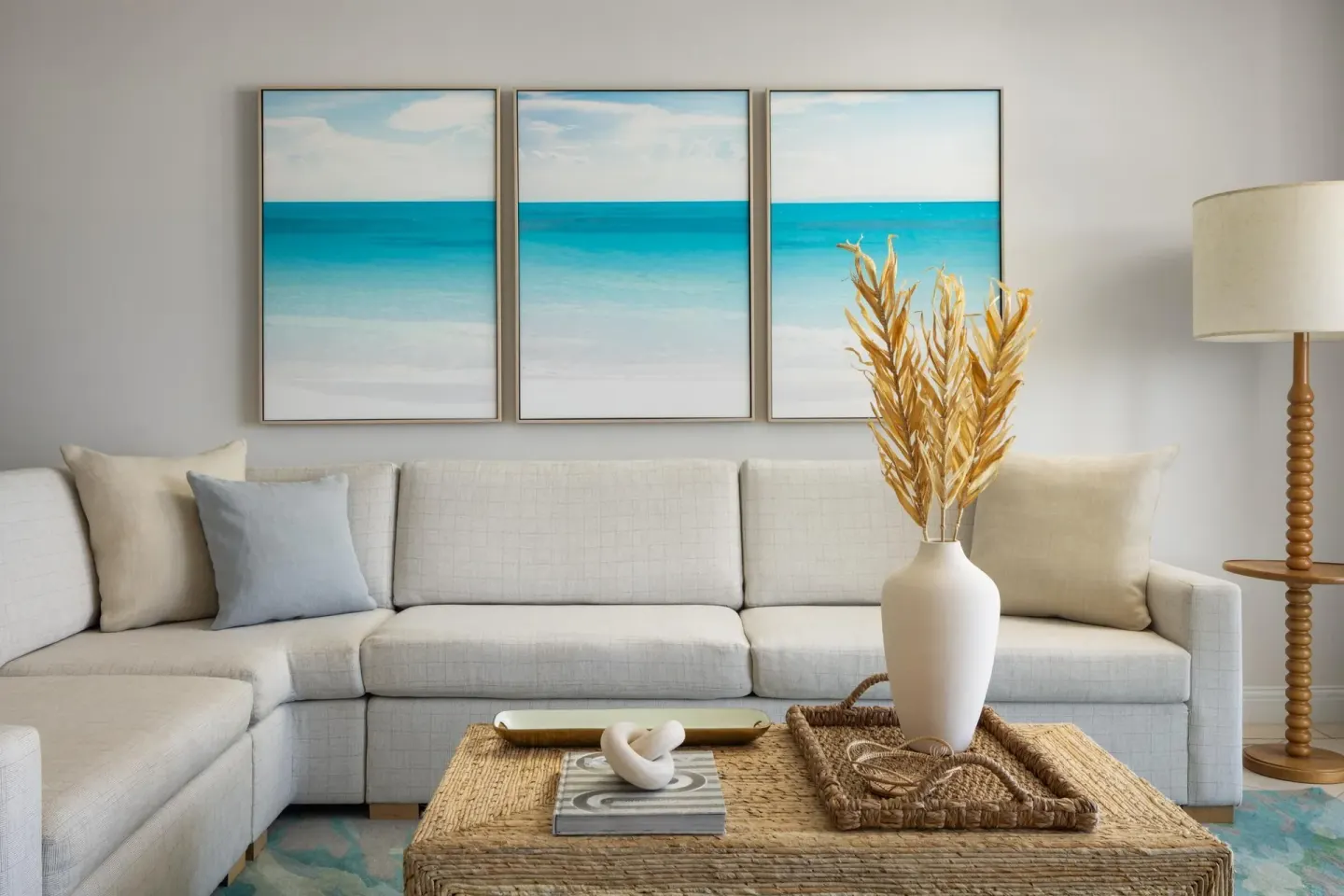 A cream sectional sofa and woven coffee table in a suite living area at Sandals Royal Bahamian.