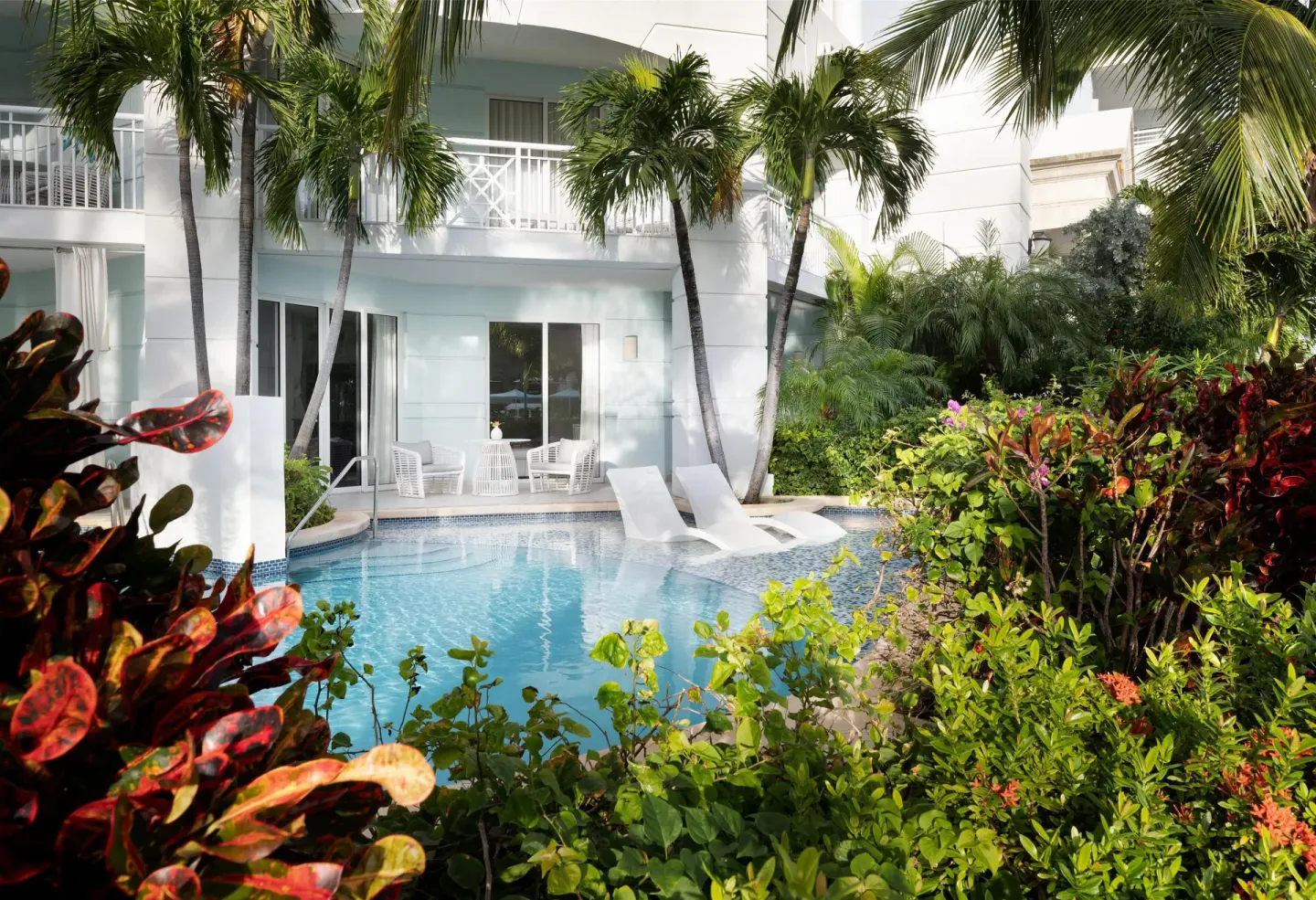 Swim-up pool area with loungers, balconies, and palms at Sandals Royal Bahamian.