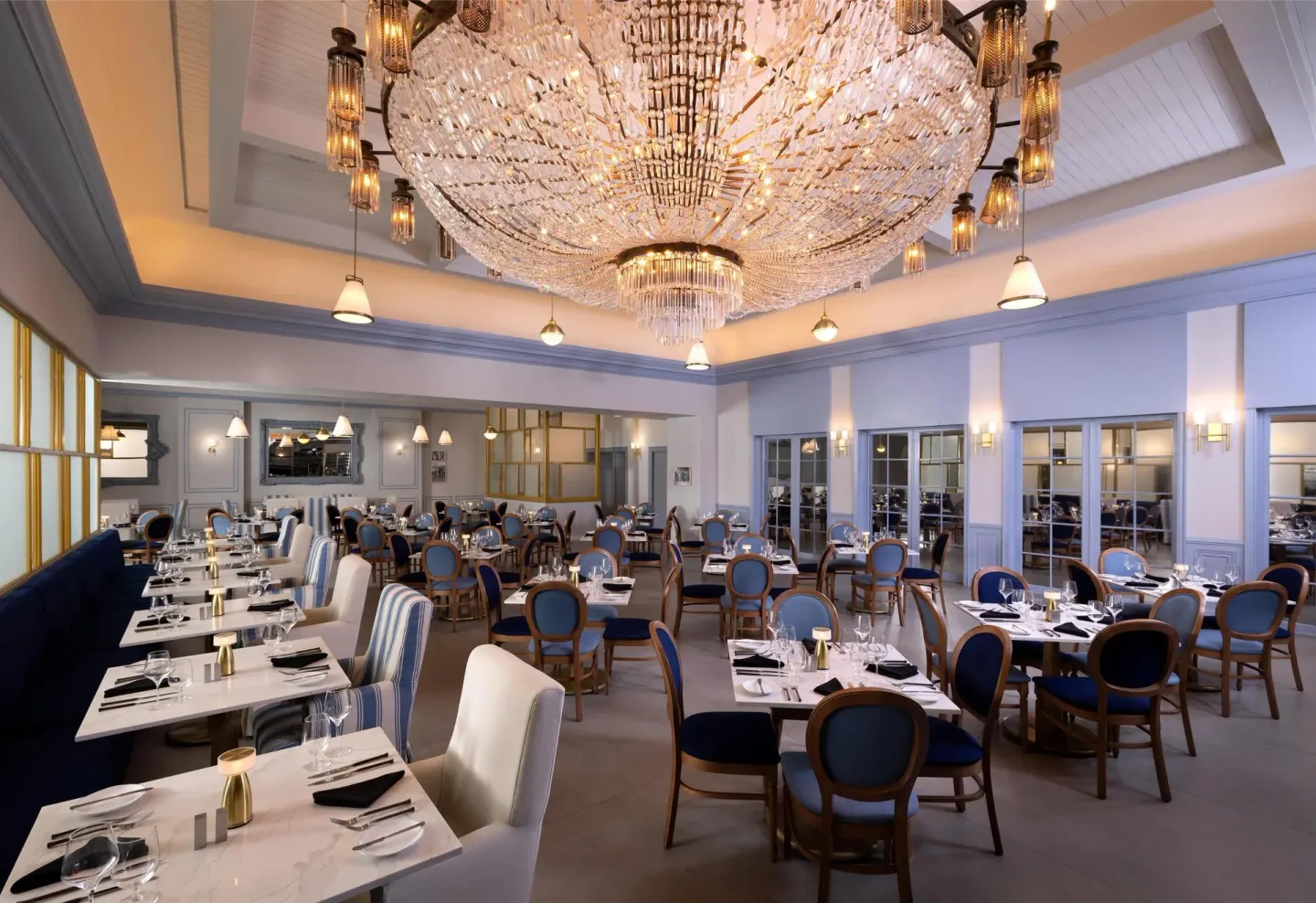 Elegant blue dining room with a large chandelier at Sandals Royal Bahamian.