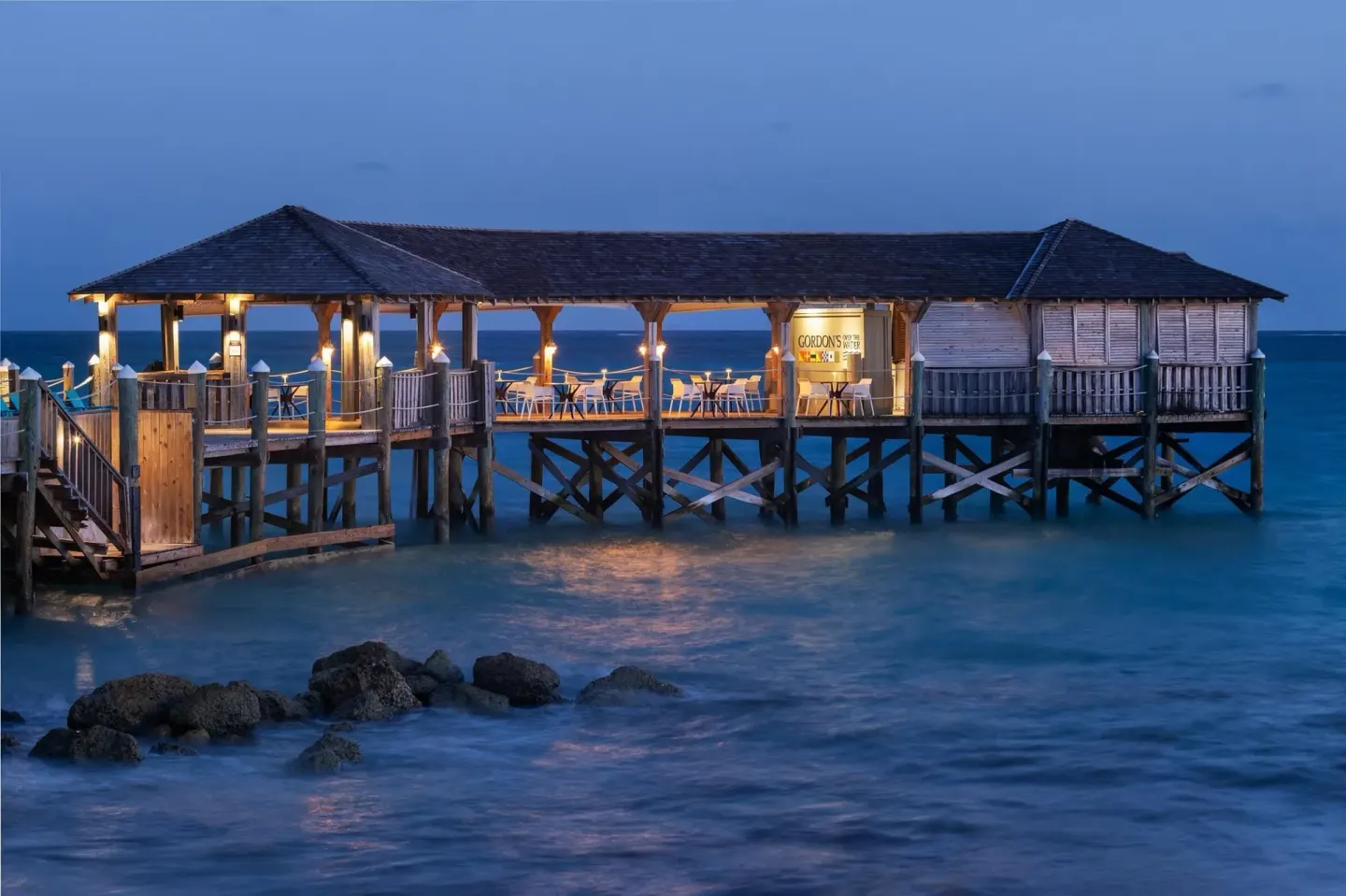 Gordon's On The Pier over the ocean at dusk at Sandals Royal Bahamian.