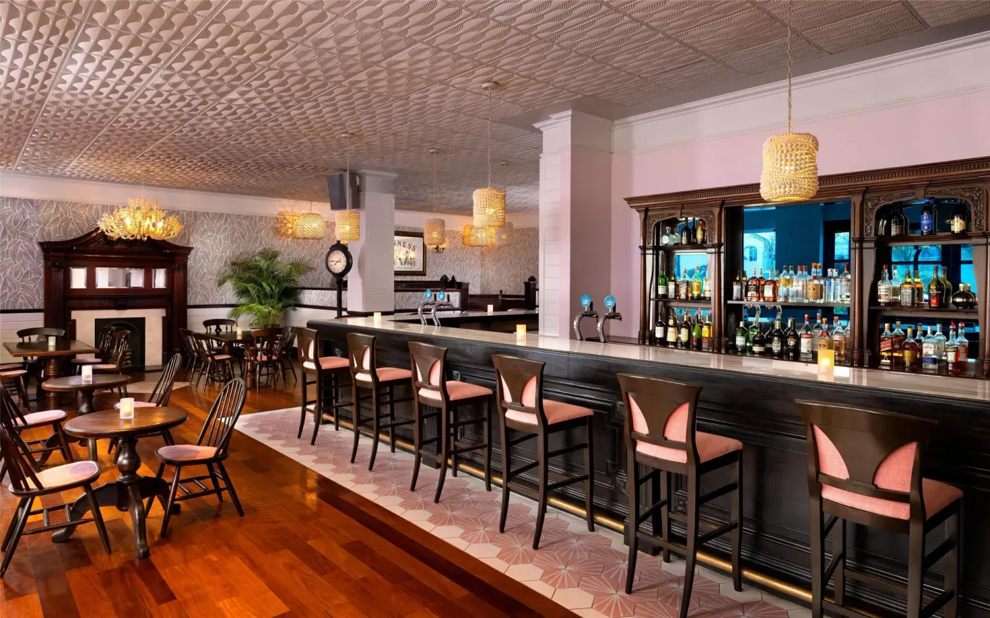 British pub bar with dark wood seating and backlit bottles at Sandals Royal Bahamian.