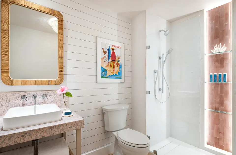 Bathroom with vanity, toilet, and glass shower in a suite at Sandals Royal Bahamian.