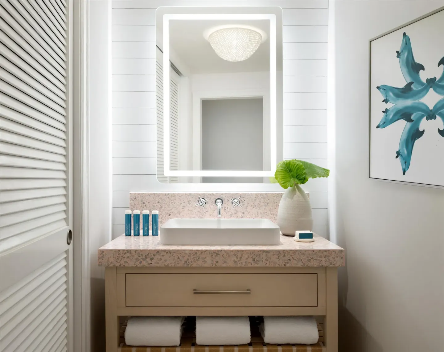 Illuminated bathroom vanity in the East Bay Honeymoon Beachfront Butler Suite at Sandals Royal Bahamian.