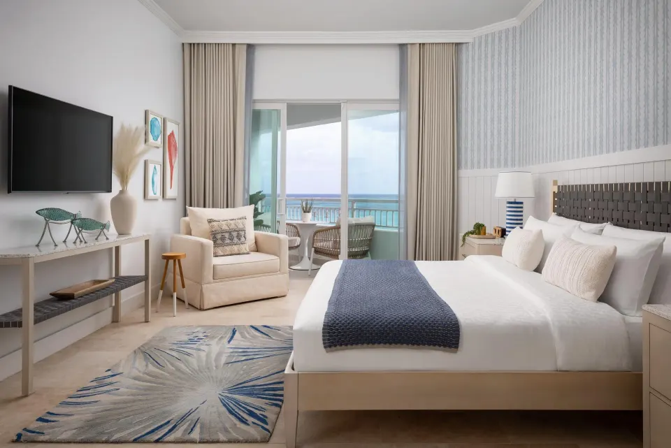 East Bay Oceanview Grande Luxe king bedroom with balcony view at Sandals Royal Bahamian.