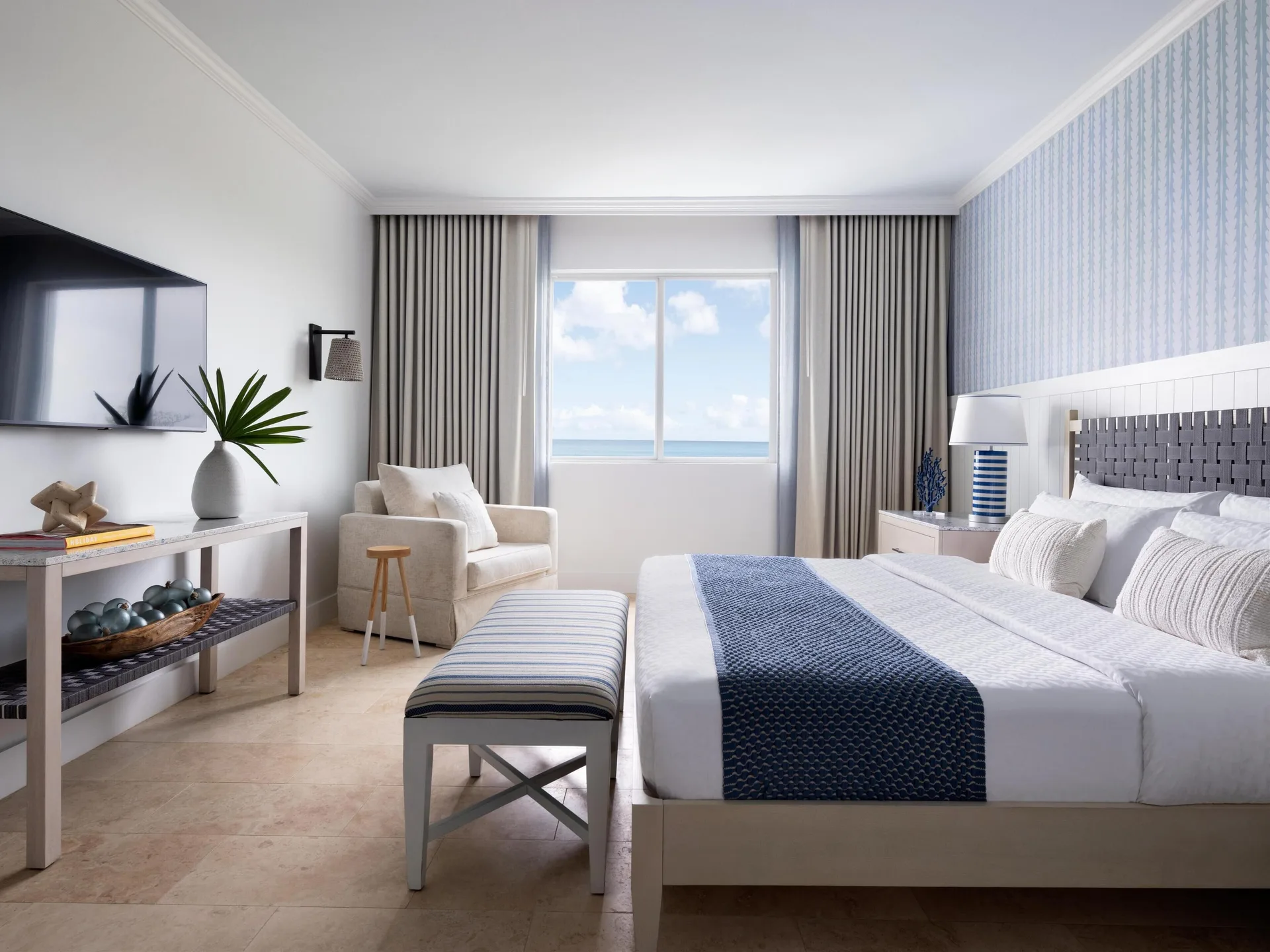 East Bay Oceanview Premium guest room with king bed and ocean-facing window at Sandals Royal Bahamian.