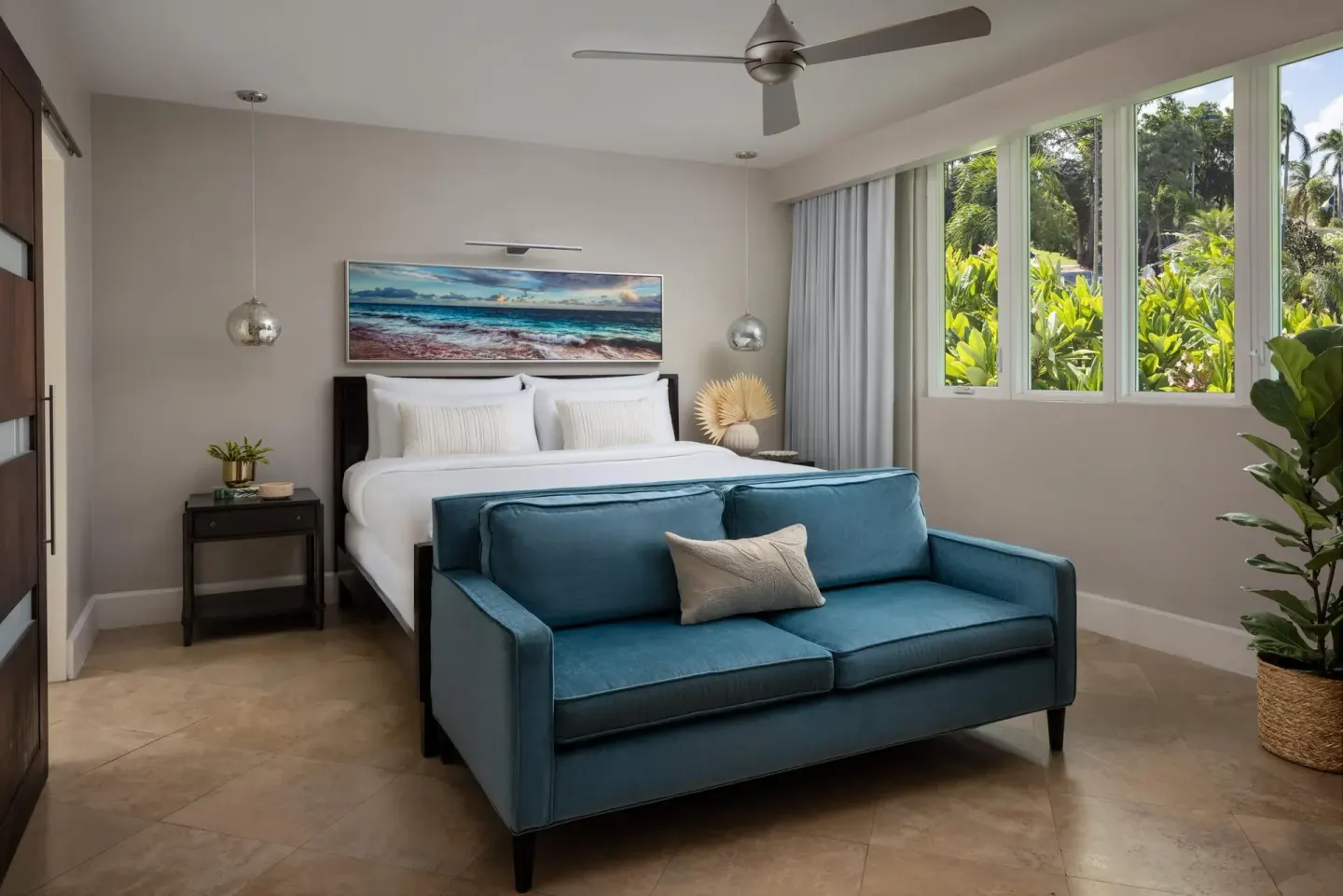 Island Village junior villa suite with king bed and blue sofa at Sandals Royal Bahamian.
