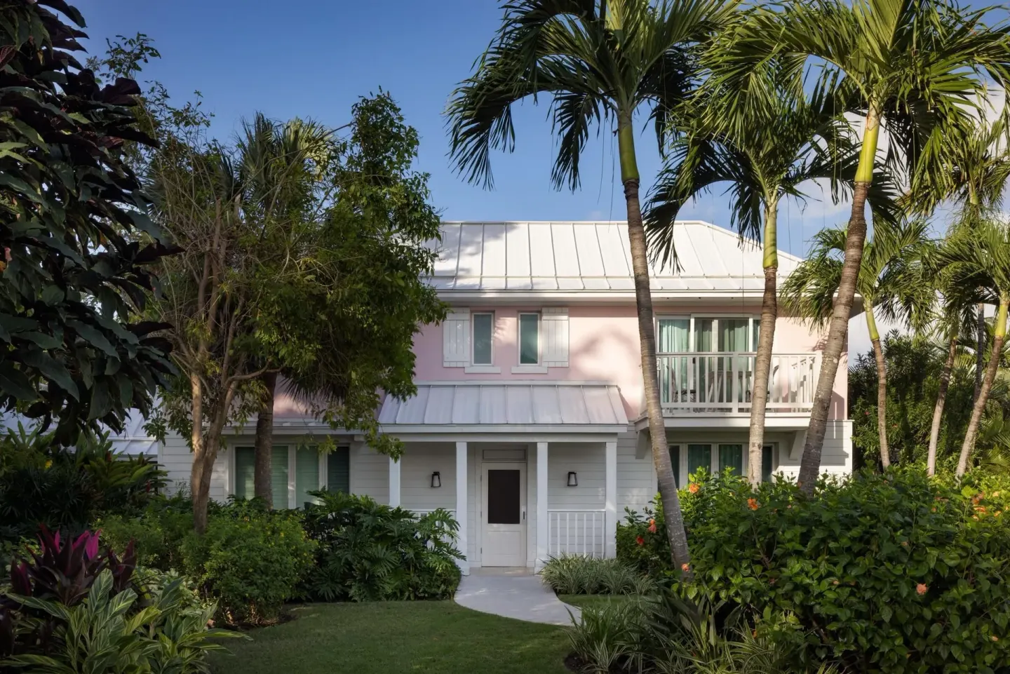 Garden path leading to a pink villa building at Sandals Royal Bahamian.