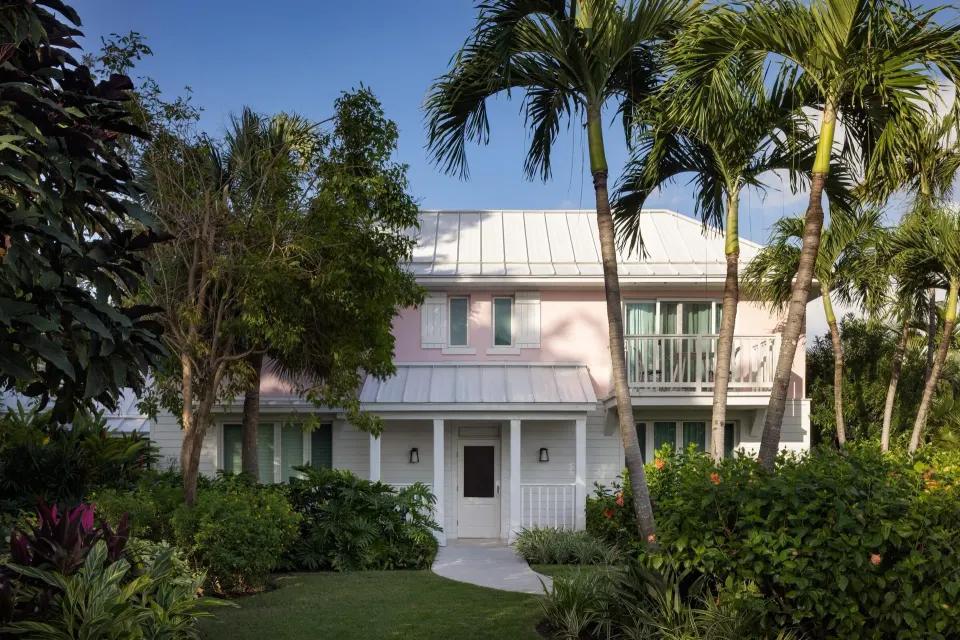Garden path leading to a pink villa building at Sandals Royal Bahamian.