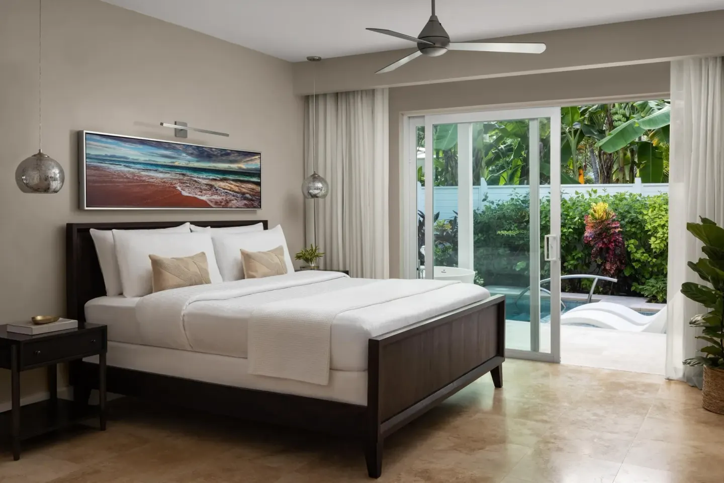 King bedroom in a private pool villa suite at Sandals Royal Bahamian opening to the pool patio.