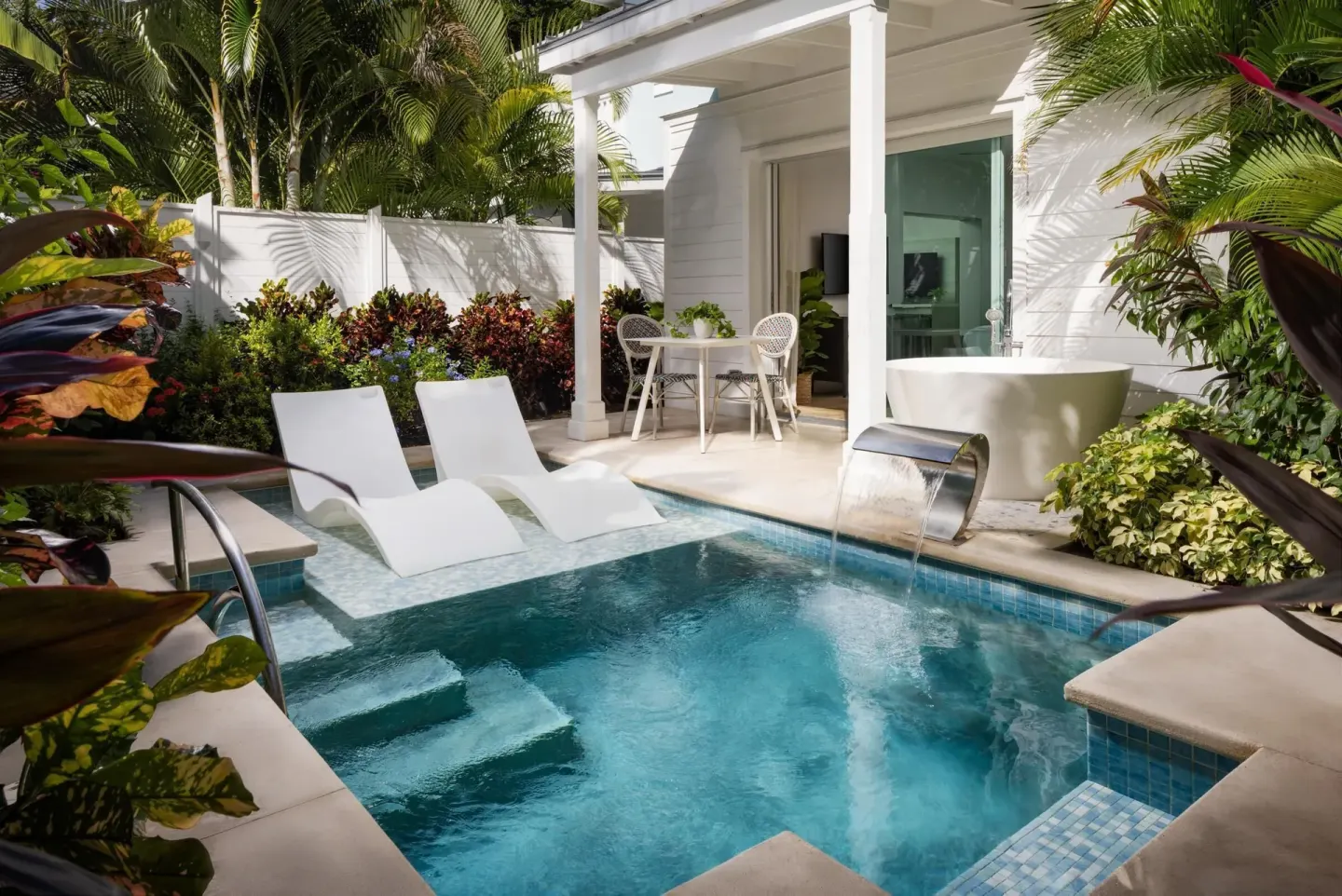 Private pool patio for a villa suite at Sandals Royal Bahamian with loungers and outdoor tub.