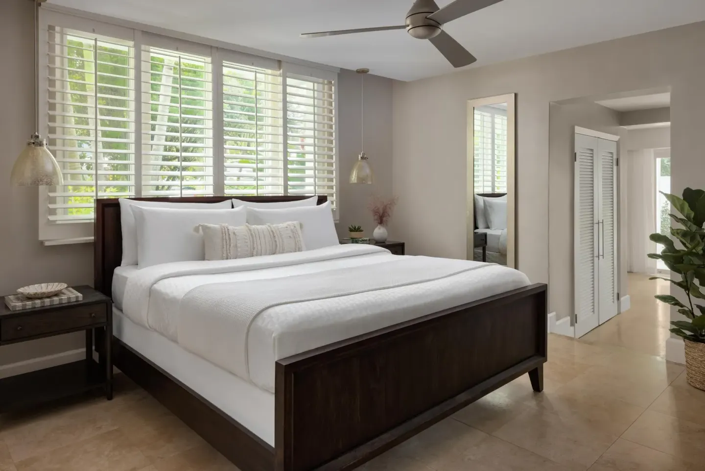 King bed in the villa bedroom with shutters at Sandals Royal Bahamian.