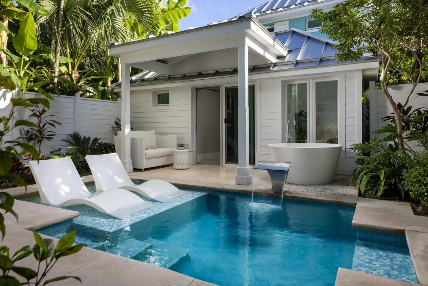 Private pool patio with loungers and outdoor tub at Sandals Royal Bahamian.