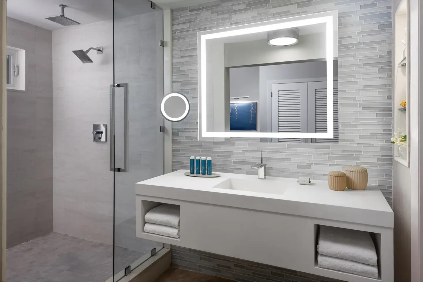Modern villa bathroom with glass shower and lighted mirror at Sandals Royal Bahamian.
