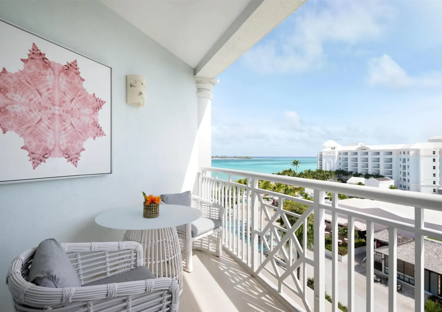 West Bay Honeymoon Oceanview Club Level Suite balcony at Sandals Royal Bahamian with white seating and ocean view.