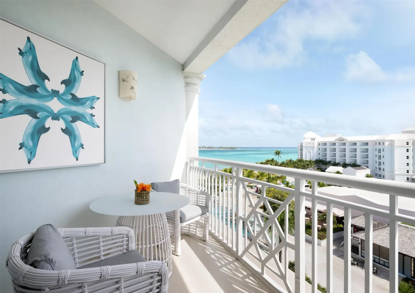 West Bay Honeymoon Oceanview Club Level Suite balcony at Sandals Royal Bahamian with blue wall art and sea view.