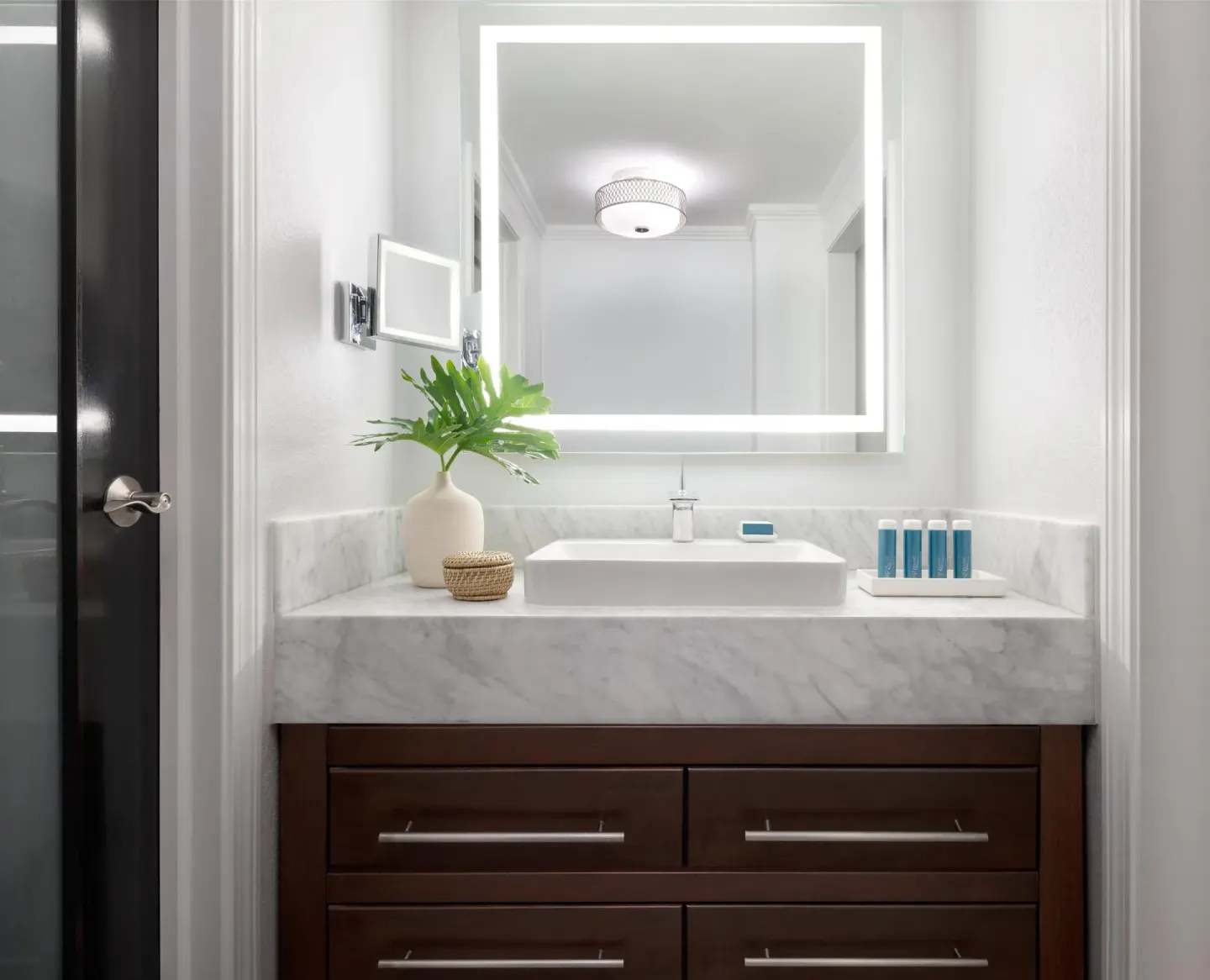 West Bay Honeymoon Oceanview Club Level Suite bathroom vanity at Sandals Royal Bahamian with lit mirror.