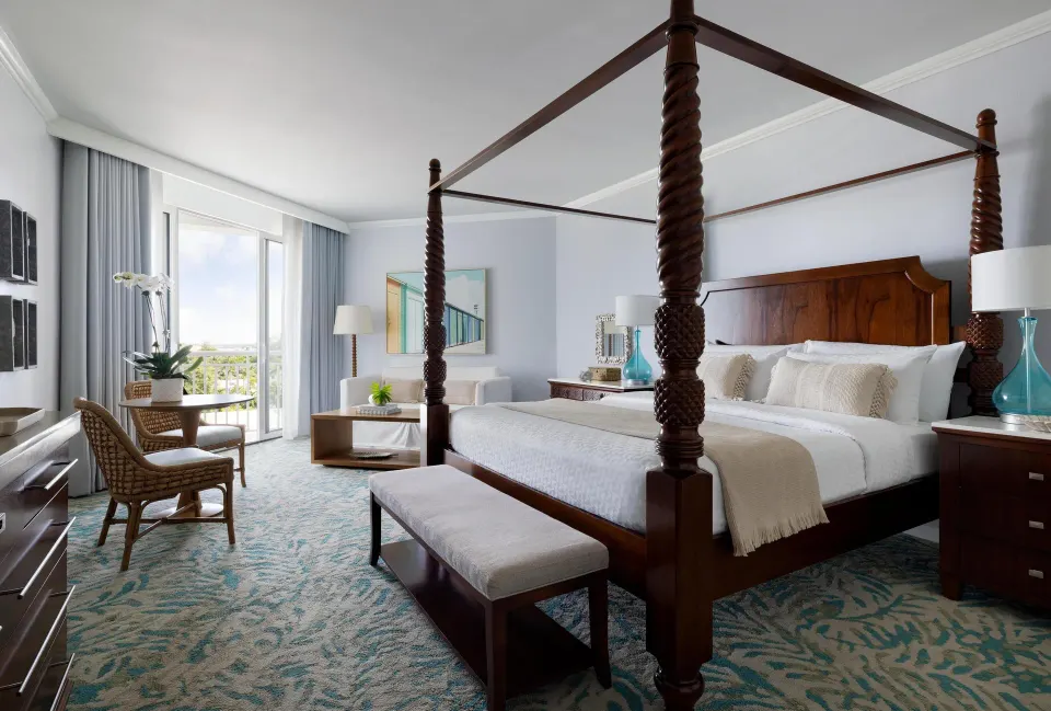 West Bay Honeymoon Oceanview Club Level Suite bedroom at Sandals Royal Bahamian with four-poster king bed.